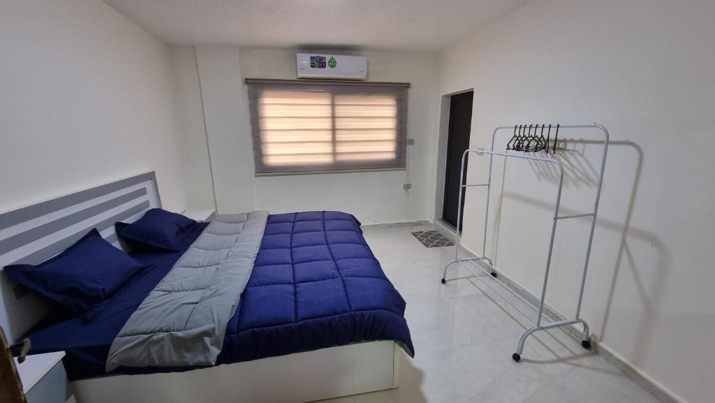 a bedroom with a blue comforter on a bed at Stay Classy Apartments in Wadi Musa