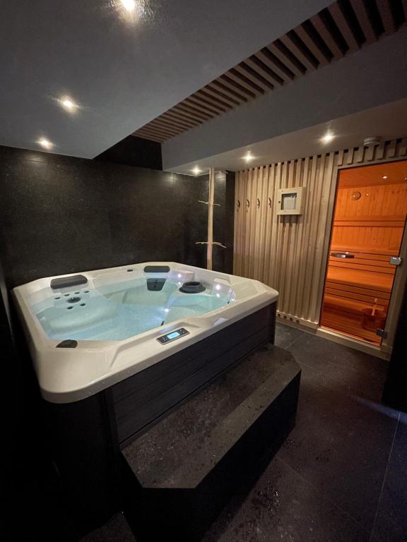 łazienka z dużą wanną w pokoju w obiekcie Dolomia Apartments & Spa w mieście Dimaro
