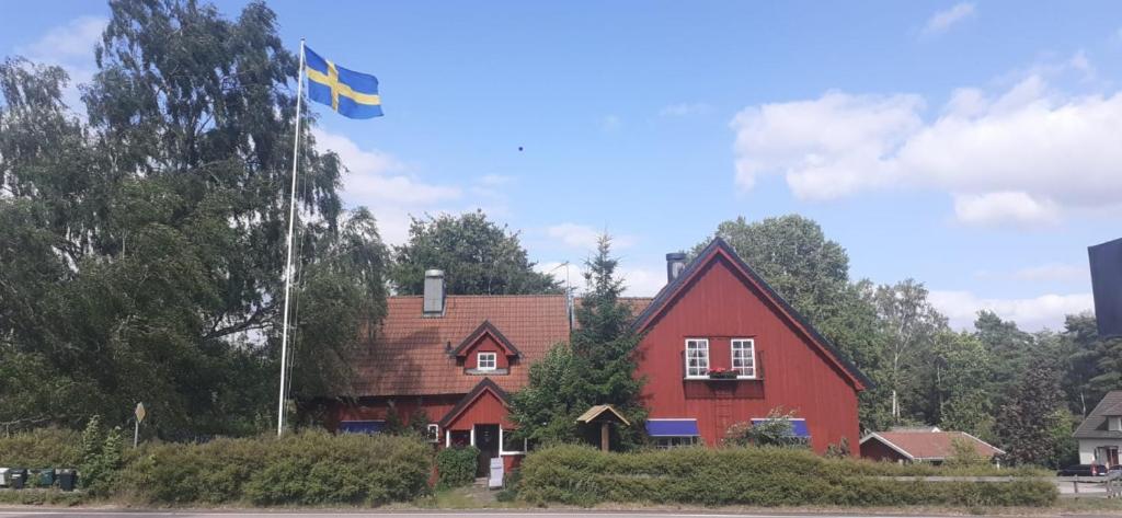 a red house with a flag in front of it at Villa Linneryd 1 in Linneryd