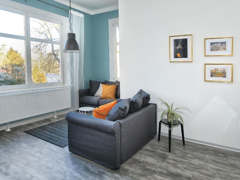 sala de estar con sofá y ventana en Moderne Ferienwohnungen in alter Villa en Georgenthal