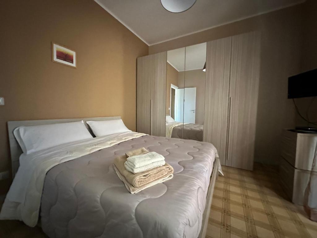 een slaapkamer met een bed met twee handdoeken erop bij Sea Sunsets - Apartments - Falerna Lido - Gizzeria Lido in Gizzeria