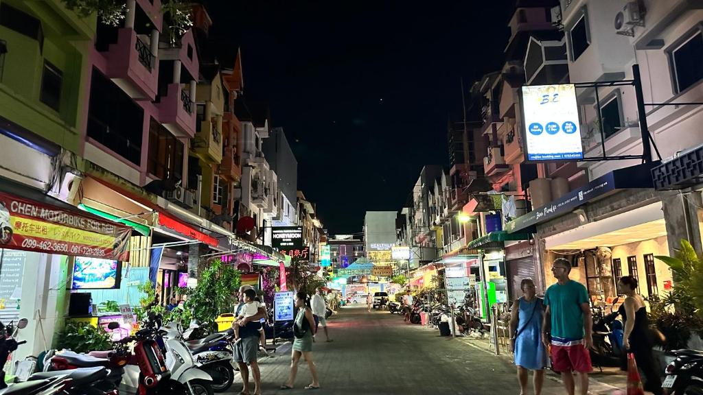 un grupo de personas caminando por una calle de la ciudad por la noche en Relax Guest House, en Patong Beach
