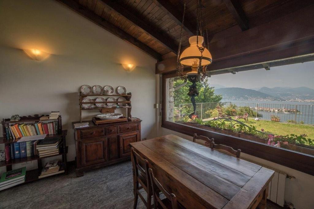 a kitchen with a large window and a wooden table at Villa Gia in Stresa