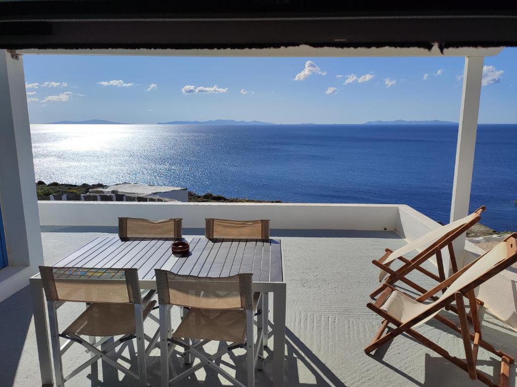 een tafel en stoelen op een balkon met uitzicht op de oceaan bij Sofia sea view apartment in Faros