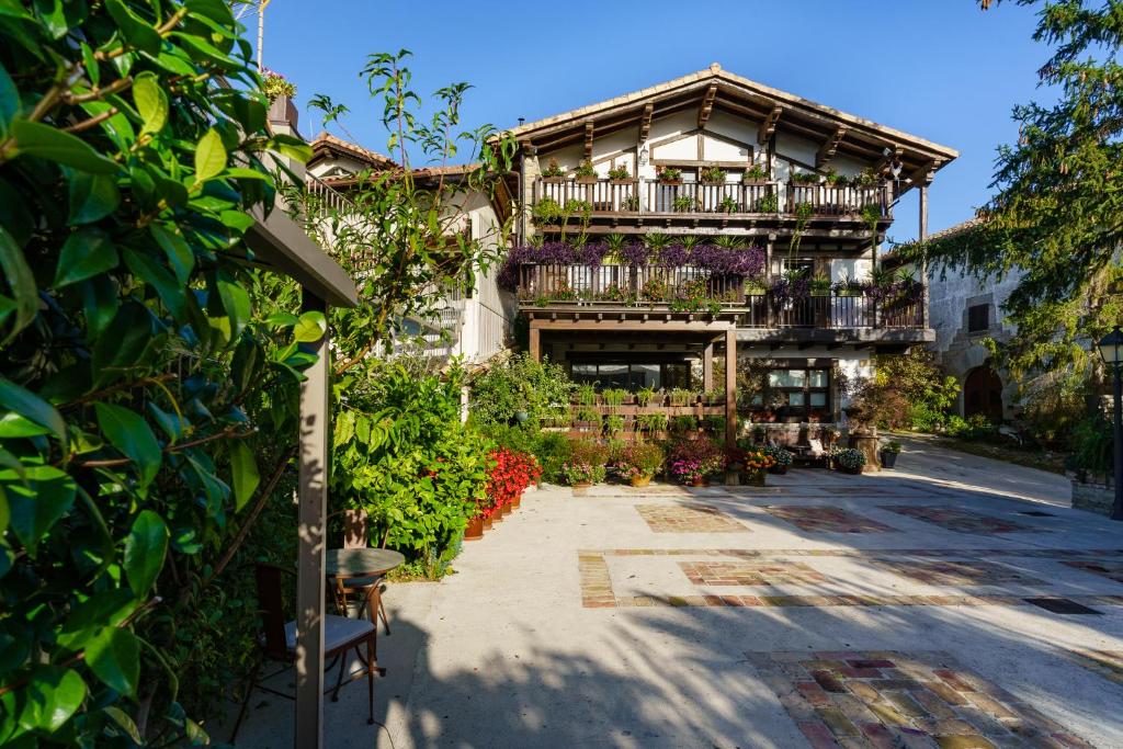 Oricáin的住宿－Villa-Mari，带阳台的建筑,庭院里鲜花盛开