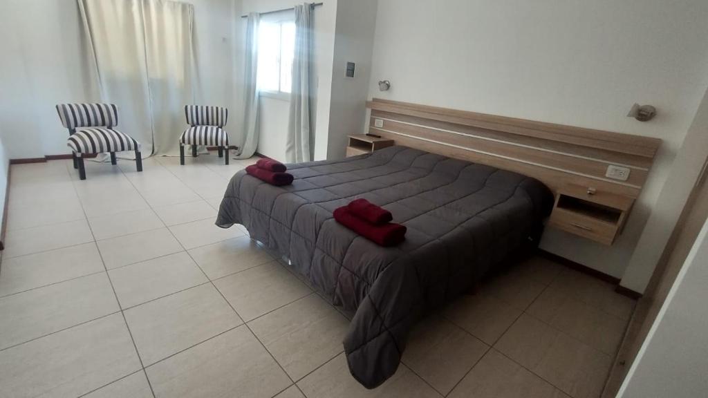 1 dormitorio con 1 cama con 2 sillas y escritorio en Gran Dúplex Plaza Independencia en Mendoza