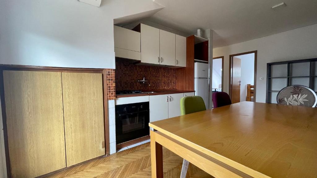 - une cuisine avec une table en bois dans une chambre dans l'établissement Apartments DS, à Osijek