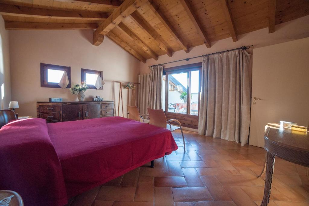 a bedroom with a red bed and a large window at Romantic Nido in Verbania