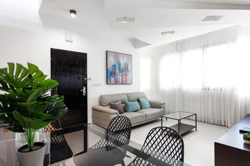 - un salon avec un canapé, une table et des chaises dans l'établissement Heart of Tel Aviv, Duplex Apartment 12, à Tel Aviv