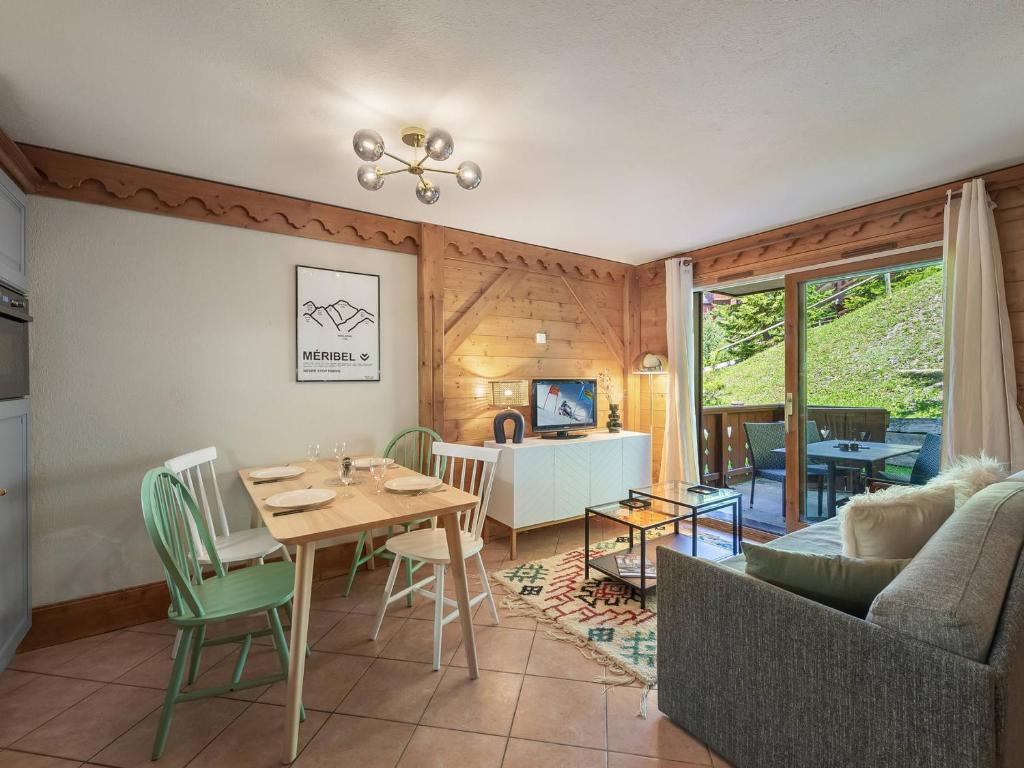 un salon avec une table et un canapé dans l'établissement Appartement cosy ski aux pieds avec piscine et spa - FR-1-566-46, à Les Allues