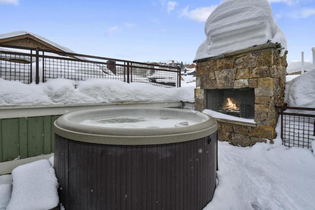 a stone fireplace in a yard with snow at The Pearl of Park City in Park City