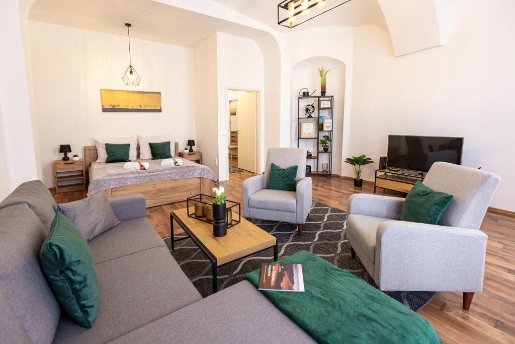 sala de estar con sofá, sillas y TV en Szabadság tér Apartment en Veszprém