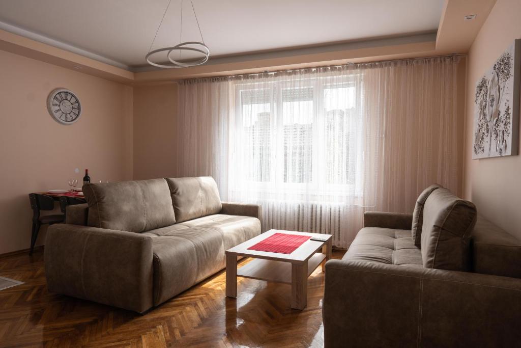 een woonkamer met een bank en een tafel bij Key Apartments in Novi Sad