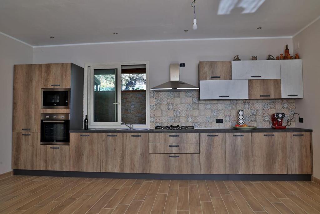 een grote keuken met houten kasten en apparaten bij Villa Valentina in Cefalù