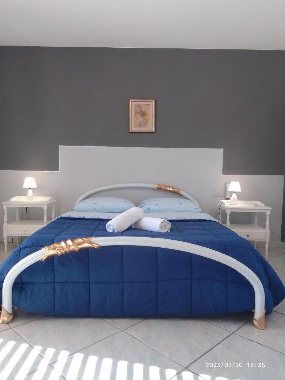 a bedroom with a blue bed with two white tables at Sea life Terrasini in Terrasini