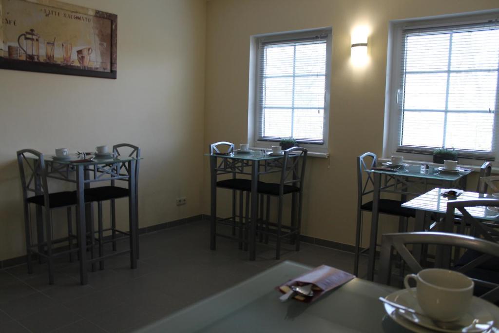 a dining room with stools and tables and windows at Hotel Pension Schwerin-Haus Schreiber in Schwerin