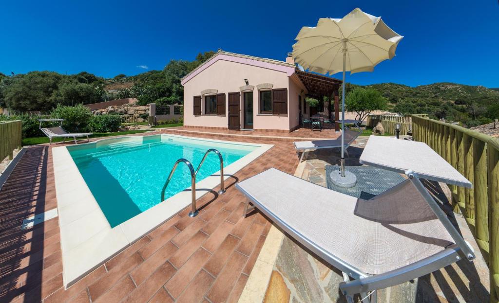 une piscine avec une table et un parasol dans l'établissement Villa Ara, à Torre delle Stelle
