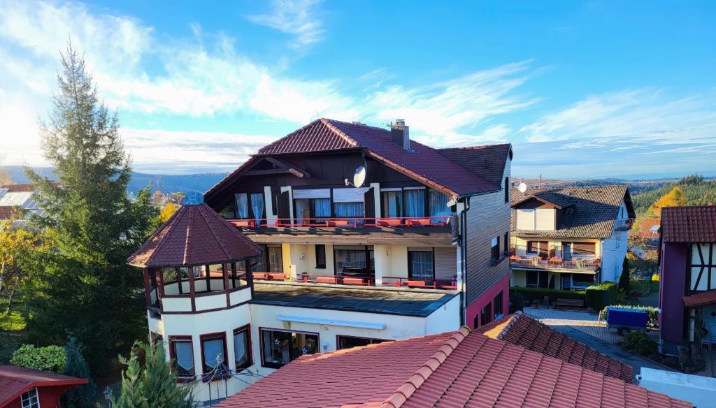 un edificio con tetto rosso e vista di Zi21 Doppelzimmer Schönblick mit Balkon a Bad Herrenalb