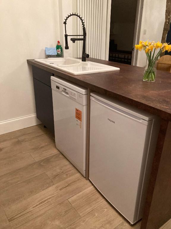 a kitchen with a sink and a dishwasher at Lime Tree Cottage in Tillingham