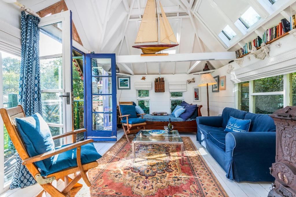 a living room with blue furniture and windows at The Folly in Dartmouth