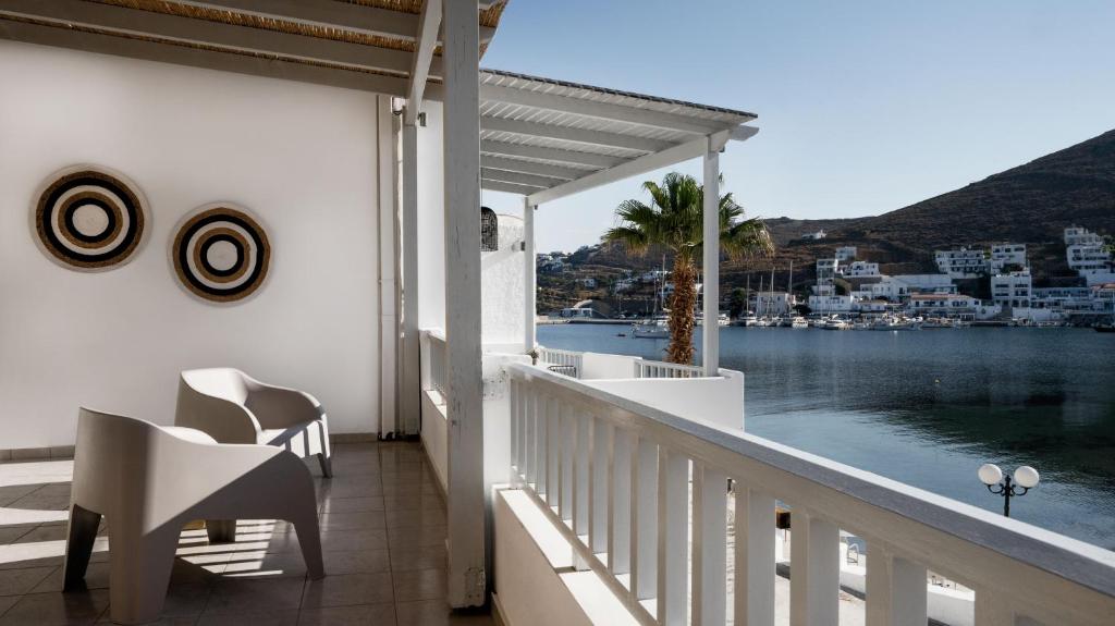 a balcony with chairs and a view of the water at Cactus Suites Kythnos in Mérikhas