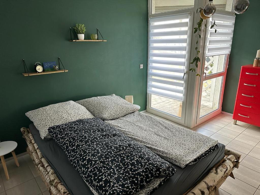 a bedroom with a bed and a green wall at Wohnung Emilia in Mörfelden-Walldorf