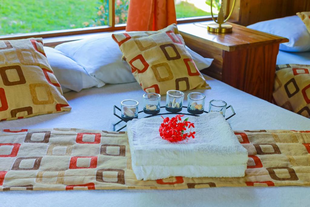 een bed met een tafel met twee glazen erop bij Casa Drake Lodge in Drake