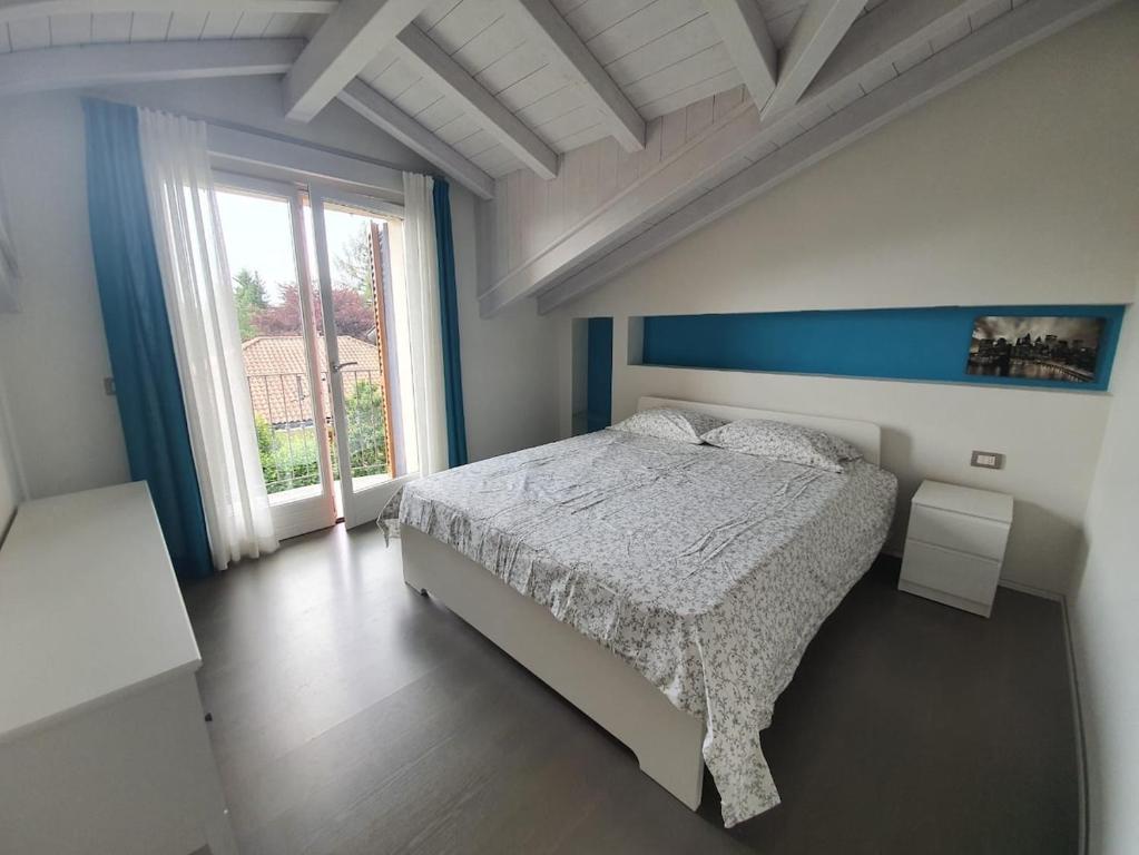 sypialnia z łóżkiem i dużym oknem w obiekcie Villa Maya w mieście Mergozzo