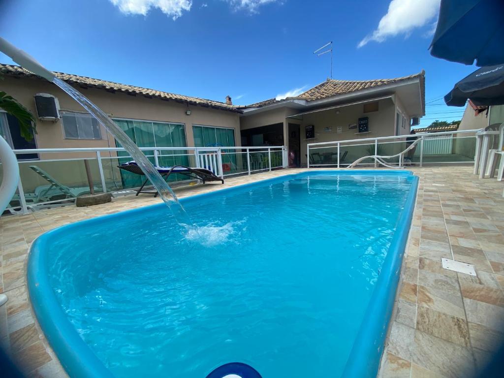 a swimming pool with a water fountain at Casa aconchegante para lazer e descanso Araruama in Araruama