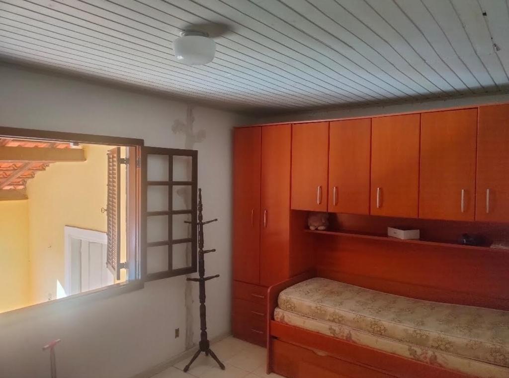 um quarto com uma cama e armários de madeira em Chácara Sonho Meu em Pinhalzinho