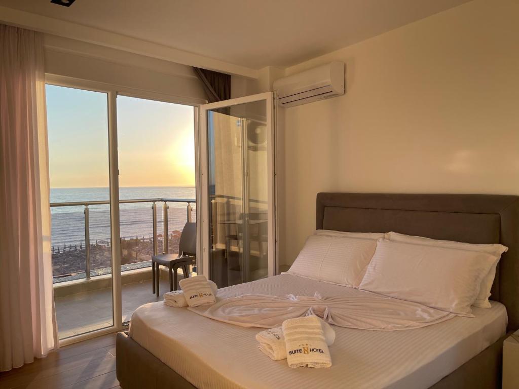 a bedroom with a bed with a view of the ocean at Suite Hotel in Shëngjin