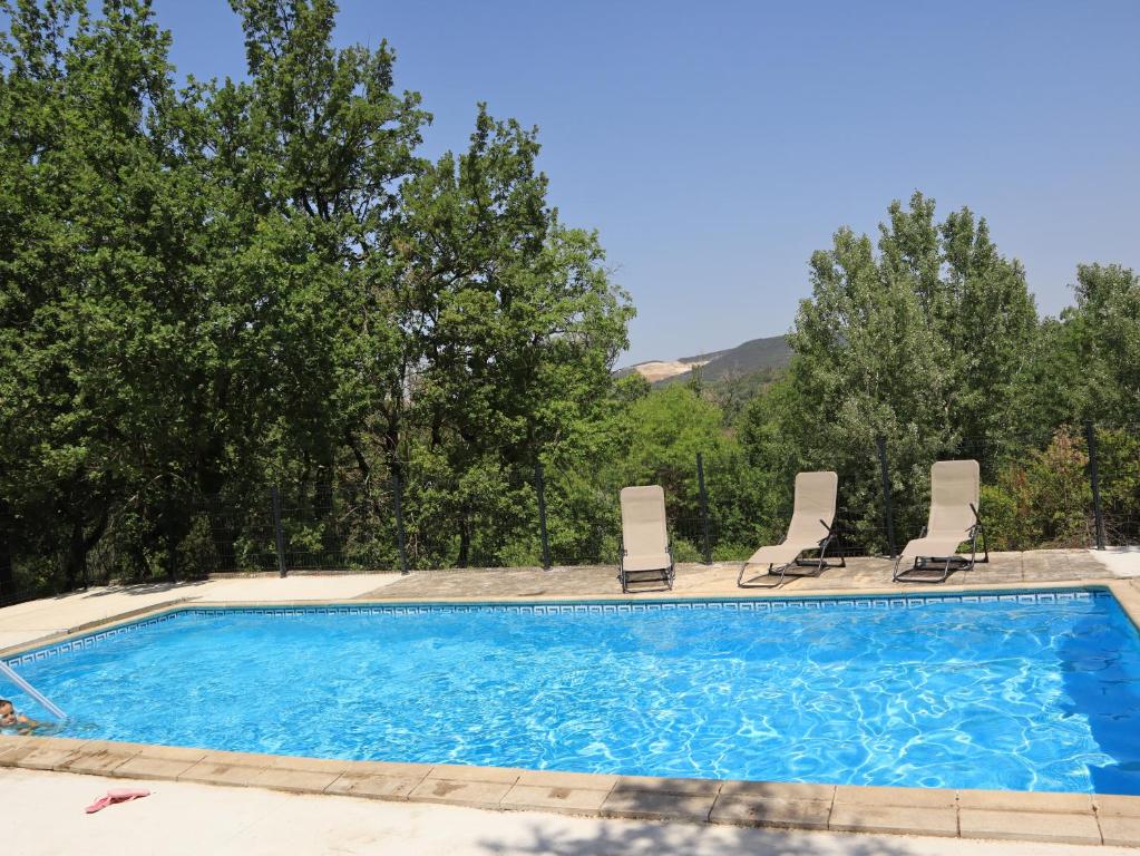 une piscine avec des chaises longues et une piscine dans l'établissement Gîte Nature et Calme du Travers, à Valaurie