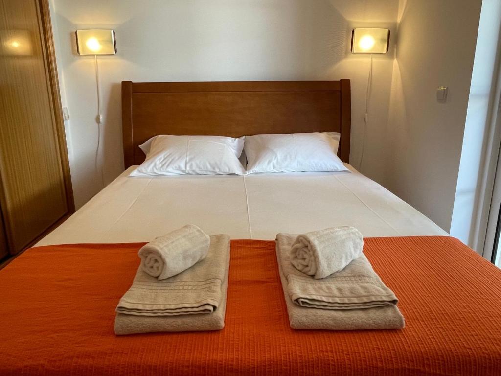 a bedroom with a bed with towels on it at A Casa do Carlos in Vila Nova de Cacela