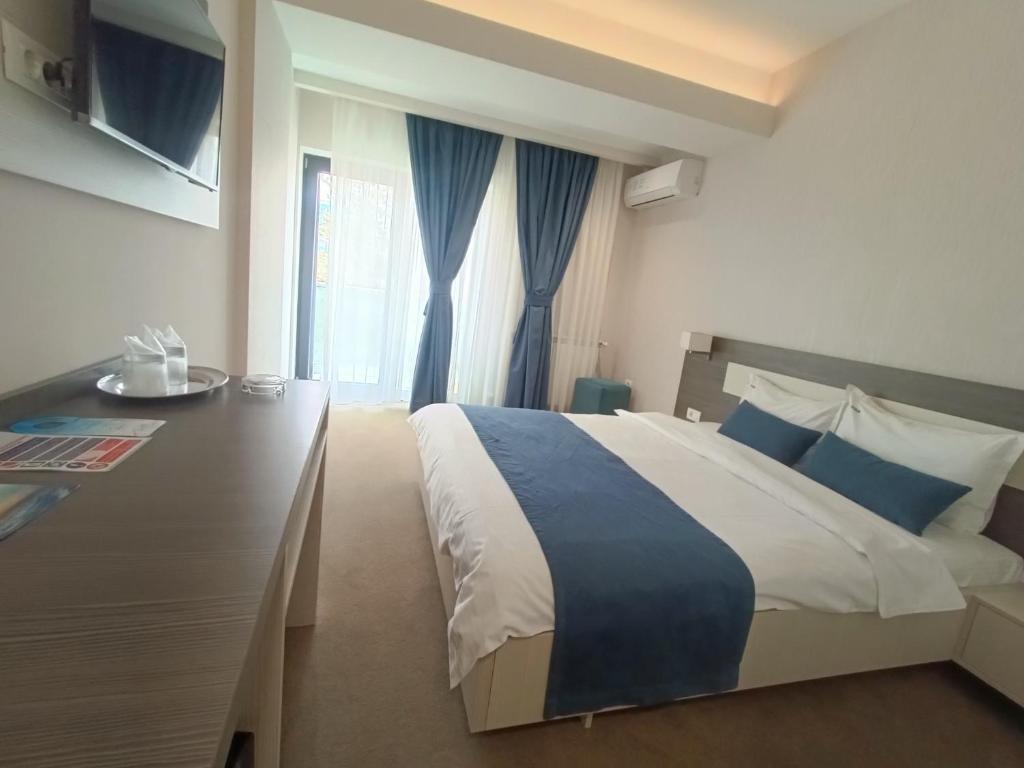 a bedroom with a large bed and a window at C&C Mamaia Studio in Mamaia