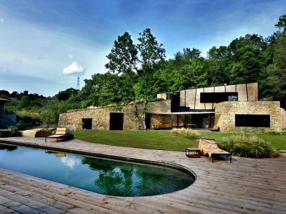 einen Hinterhof mit einem Pool und einem Gebäude in der Unterkunft Casa japandi Un alojamiento saludable in Sant Juliá de Vilatorta