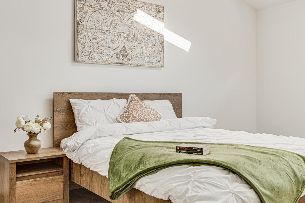 a bedroom with a bed with a green blanket on it at ARI Central Skyview Apartment in Arad