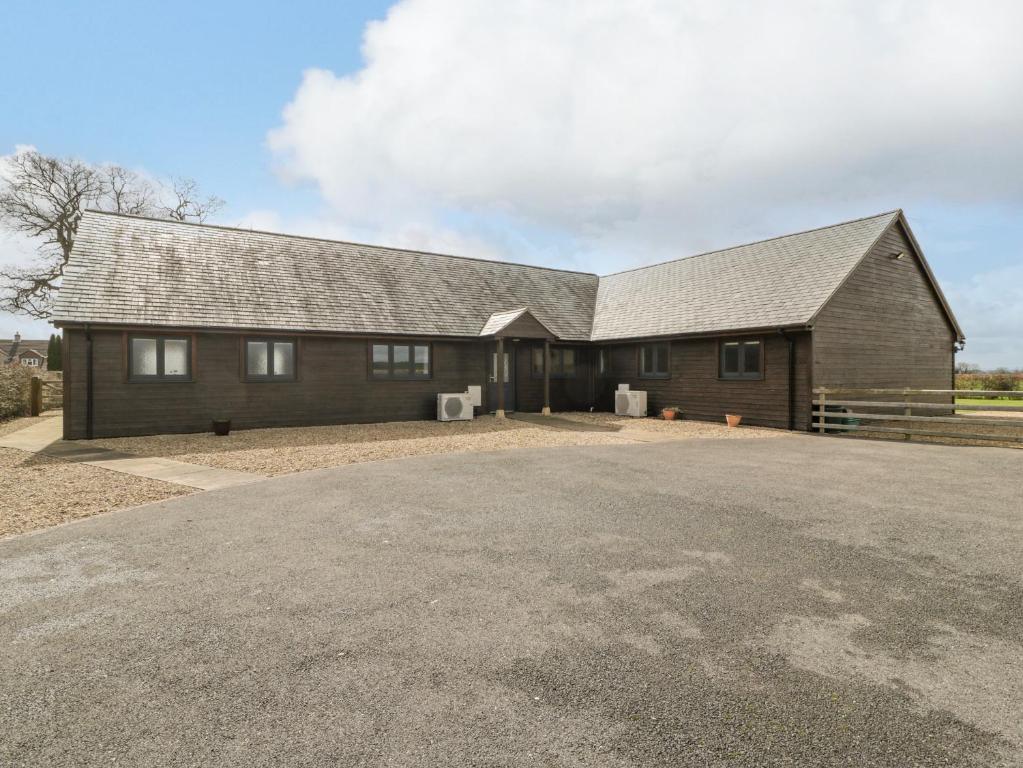 een groot huis met een grote oprit ervoor bij Rectory Farm Lodge in Queen Camel