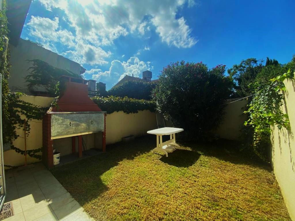 a small white bench sitting in a yard at Casa Storni in Mar del Plata