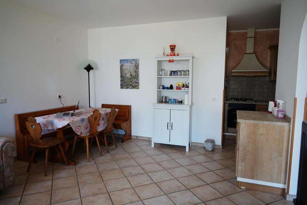 cocina y comedor con mesa y sillas en Appartamento I Castagneti, en Pasturo