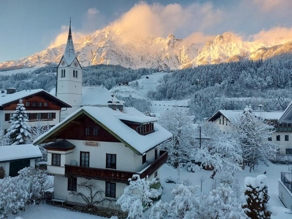 a village covered in snow with mountains in the background at Appartement Leni Leogang in Leogang