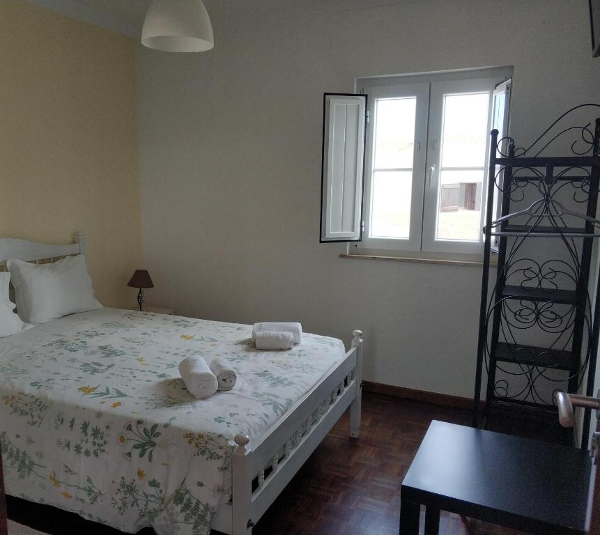 ヴィラ・ノヴァ・デ・ミルフォンテスにあるAlojamentos Vitinho 2 - Vila Nova Milfontesのベッドルーム1室(ベッド1台、タオル2枚付)
