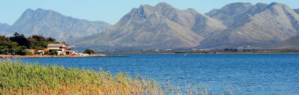 a large body of water with mountains in the background at Fisherhaven Guest House in Hermanus