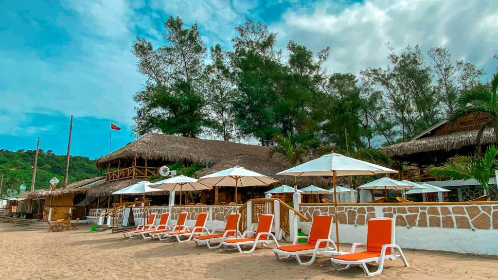 a group of chairs and umbrellas on a beach at HANGA ROA HOTEL in Montañita