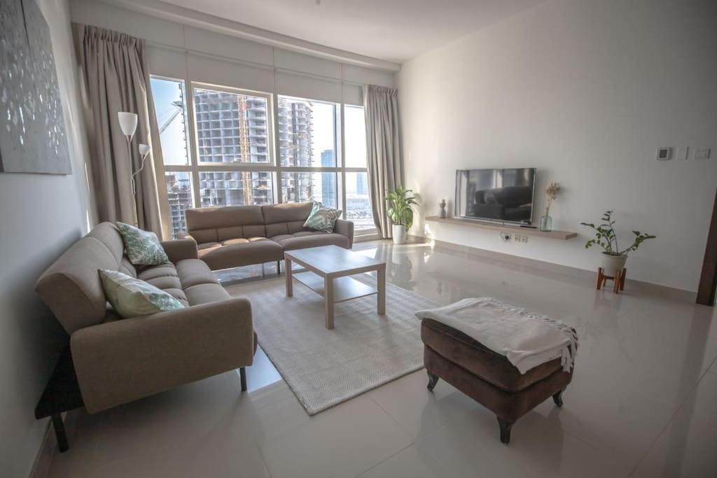 a living room with two couches and a tv at We love having you here in Abu Dhabi