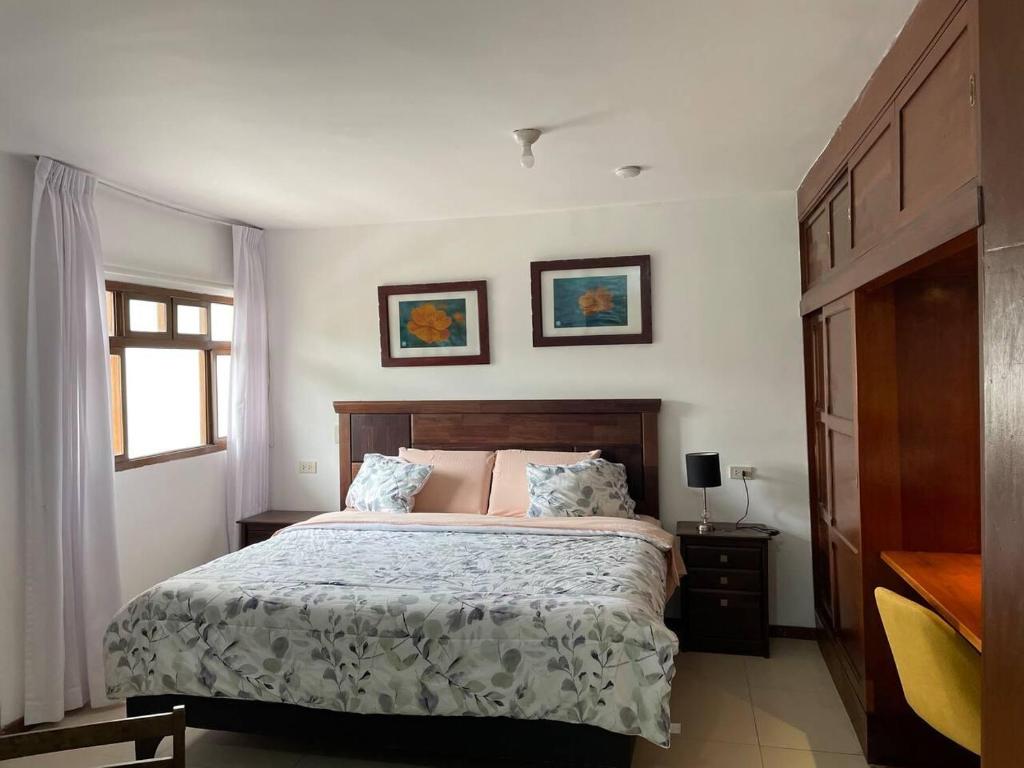 1 dormitorio con 1 cama y 2 cuadros en la pared en Charming and impeccable 1-Bed Studio in Huanchaco, en Huanchaco