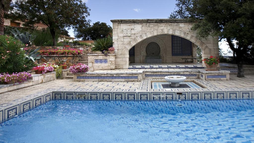 a swimming pool with a fountain in a yard at les arbousiers in Céret