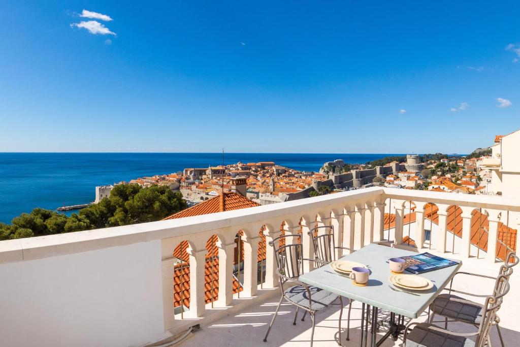 uma varanda com uma mesa e cadeiras e o oceano em Apartment Kekia em Dubrovnik