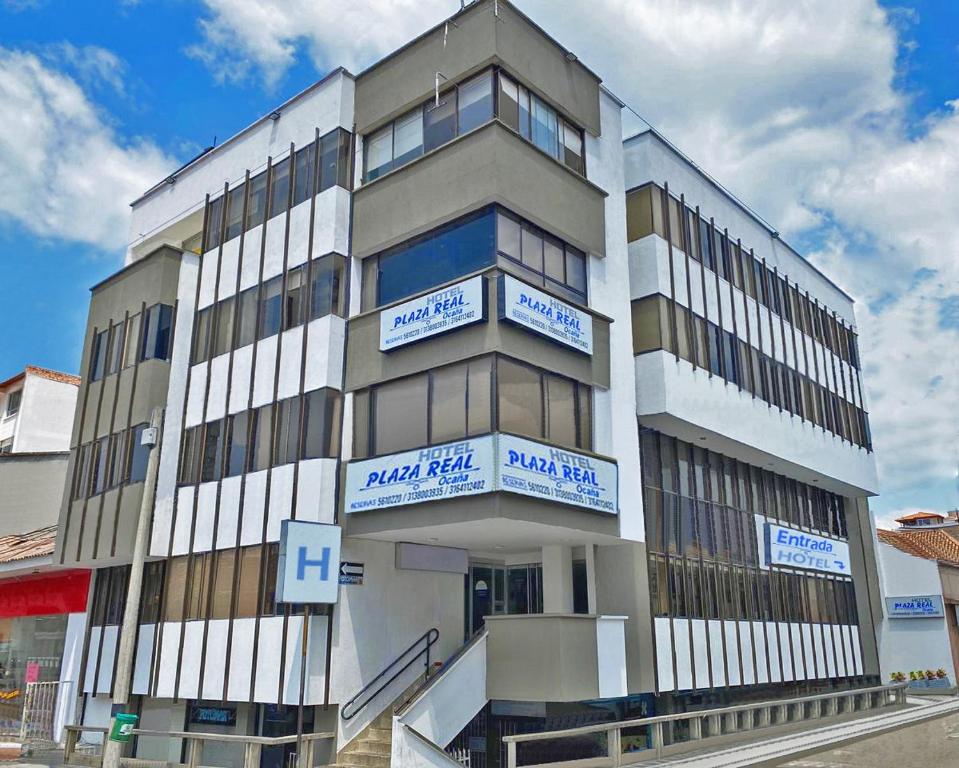 a tall building with blue and white signs on it at Hotel Plaza Real Ocaña in Ocaña