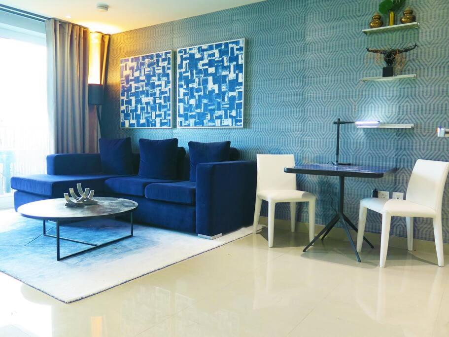 a living room with a blue couch and white chairs at Club White London Bridge One Bedroom Apartment in London