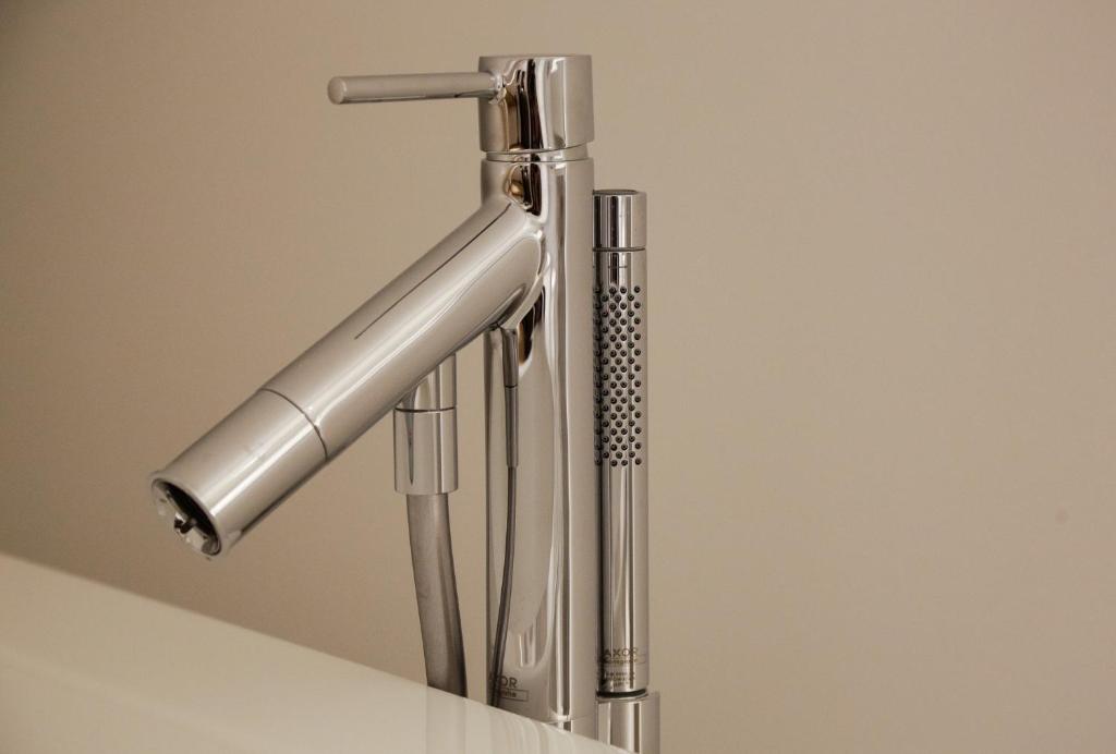 a stainless steel sink faucet in a bathroom at La Pipistrelle Hotel in Luxembourg